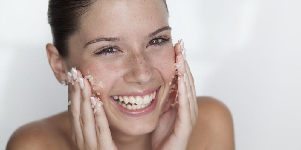 The girl prepares the skin for rejuvenation at home with peeling. 